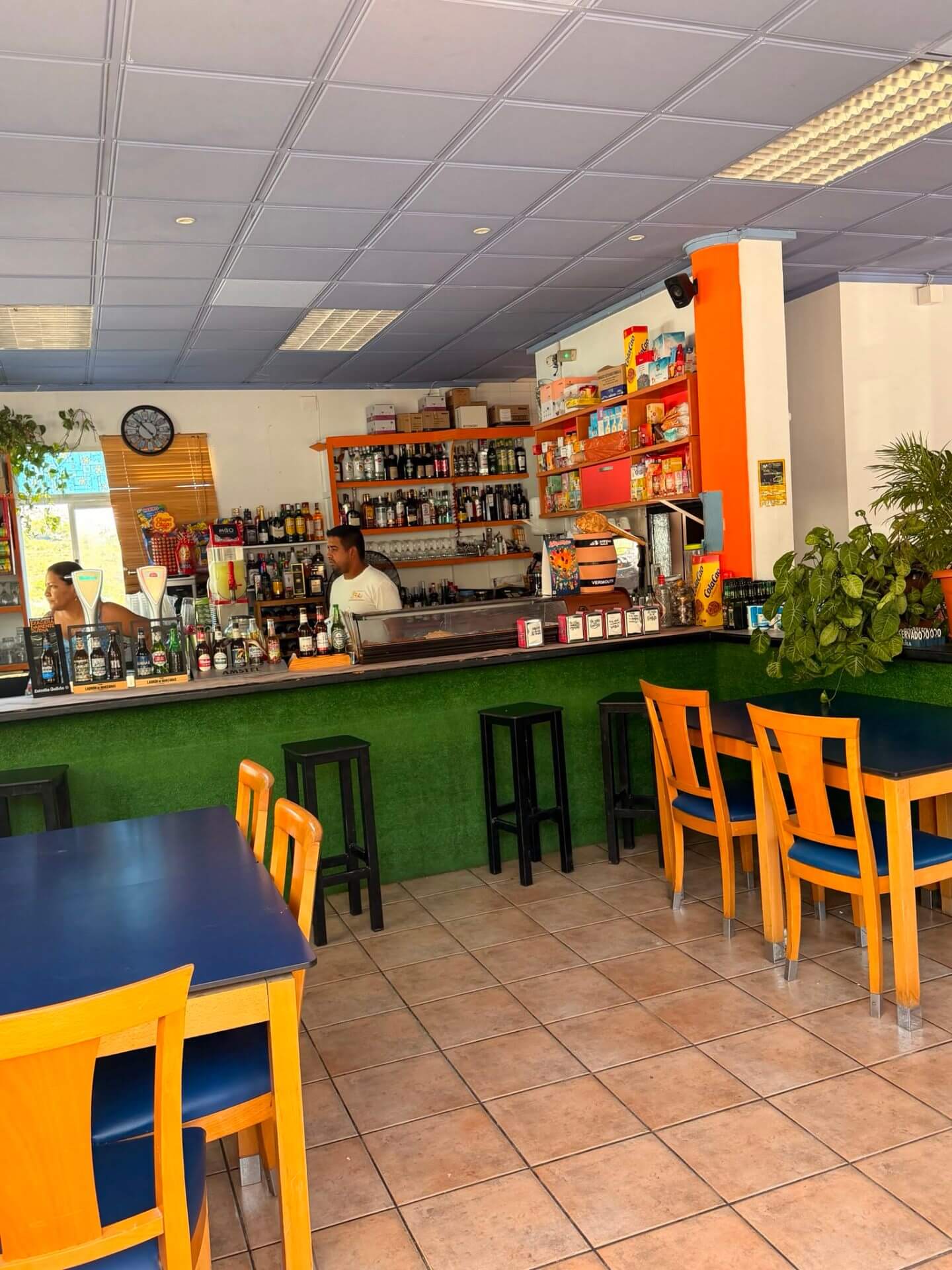 Le comptoir du bar Sa Piscina avec bouteilles, machine à café et tabourets