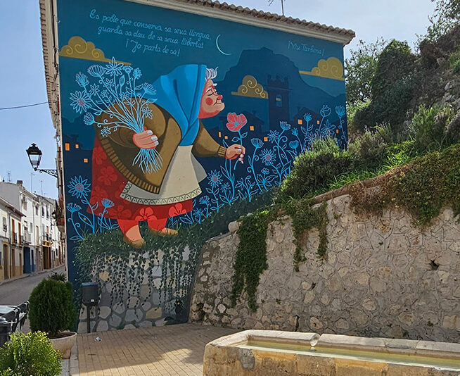 Fresque colorée d'une femme avec des fleurs dans une rue de Tàrbena